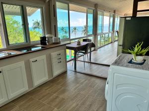 a kitchen with white cabinets and a view of the ocean at Grand view @lamaibeach in Koh Samui 