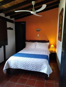 モンテネグロにあるAlojamiento rural finca estrella del Quindíoのベッドルーム1室(ベッド1台、シーリングファン付)