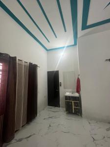 Habitación con techo azul, cortinas y espejo. en Grewal homestay, en Jalandhar