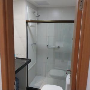 a bathroom with a glass shower with a toilet at Mana beach class experience in Porto De Galinhas