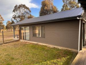 a house with a solar roof on a yard at Wallaby Lodges in Pokolbin