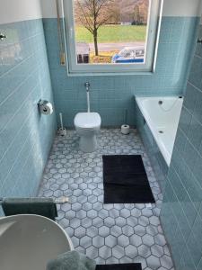 ein Bad mit einem WC, einer Badewanne und einem Fenster in der Unterkunft Geräumiges Monteurzimmer für 2 Personen in Lauda-Königshofen