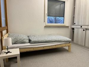 ein kleines Bett in einem Zimmer mit Fenster in der Unterkunft Geräumiges Monteurzimmer für 2 Personen in Lauda-Königshofen