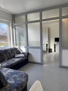 a living room with a couch and a large window at Geräumiges Monteurzimmer für 2 Personen in Lauda-Königshofen