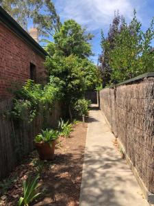a sidewalk next to a brick wall and a fence at MRS BROWN’s COMFY CITY PAD in Norwood