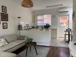 a living room with a couch and a kitchen at MRS BROWN’s COMFY CITY PAD in Norwood