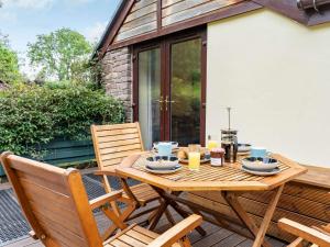 - une table en bois et 2 chaises sur la terrasse dans l'établissement 2 Bed in Llangenny BN284, à Llangenny