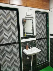 uma casa de banho com um lavatório e um espelho em Kailasha - Hostel Cum PG em Mumbai