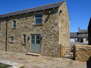 a stone building with a green door and a fence at 1 Bed in Durham HISHO in Lanchester