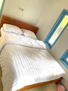 Ce lit se trouve dans une petite chambre dotée d'une fenêtre. dans l'établissement Batubutir homestay, à Midang