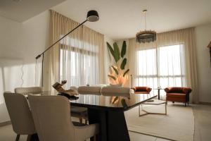 a living room with a table and chairs at Brand New l Stylish and Spacious 2BR in Madinat Jumeirah in Dubai