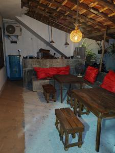 a living room with wooden tables and red pillows at Aurora Echo Villa in Matara