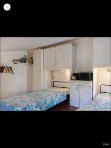 two beds in a small room with white cabinets at Casa Porticciolo in Rio Marina