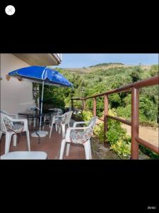 - un balcon avec des chaises et une table avec un parasol dans l'établissement Casa Porticciolo, à Rio Marina