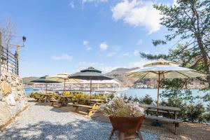 un grupo de mesas con sombrillas junto a un lago en SS Resort en Gapyeong