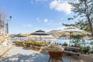 a group of tables with umbrellas next to a lake at SS Resort in Gapyeong