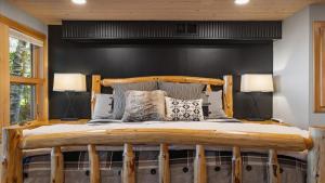 ein Schlafzimmer mit einem Holzbett mit zwei Lampen in der Unterkunft New! The Stone House On Pelican Lake in Breezy Point
