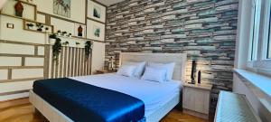 sypialnia z dużym łóżkiem i kamienną ścianą w obiekcie Comfort 14 -- Stylish City Apartment Netflix, Wi-Fi & Parking w Miszkolcu +32 zdjęcia