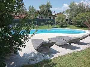 una piscina con 2 bancos y una mesa y sidx sidx sidx sidx en Villa Rosetta wellnes relax, en Scrutto