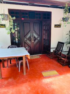 a room with a table and chairs in front of a door at Little Cottage in Ella
