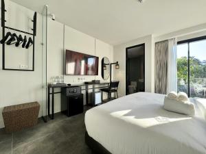 a hotel room with a bed and a desk and a desk at POR Singharat in Chiang Mai