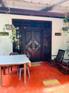 a room with a wooden door and a table and chairs at Little Cottage in Ella