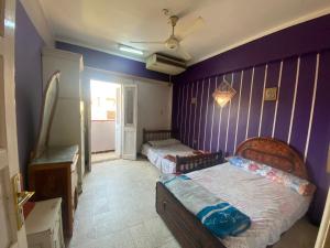 盧克索的住宿－Mayane home，一间卧室设有两张床和紫色墙壁