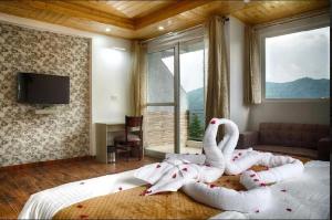 um quarto com uma cama com dois cisnes em Green Valley Chail em Chail