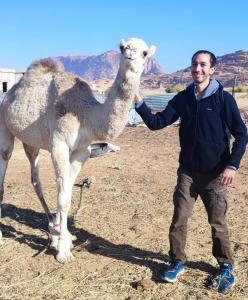 Un homme se tient à côté d'un chameau dans l'établissement Bedouin experiences, à Aqaba