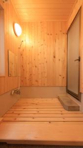 a room with a sauna with wooden walls and a lamp at Kusatsu onsen Futabaya in Kusatsu