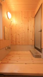 a room with a sauna with wooden walls and a lamp at Kusatsu onsen Futabaya in Kusatsu