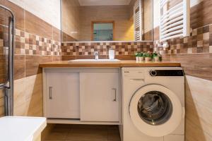 W łazience znajduje się pralka i umywalka. w obiekcie Comfort 14 -- Stylish City Apartment Netflix, Wi-Fi & Parking w Miszkolcu