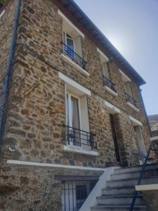 um edifício de tijolos com escadas e janelas em Villa proche JO 2024 em La Courneuve