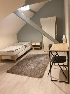 um quarto com uma cama, uma cadeira e um tapete em Villa proche JO 2024 em La Courneuve