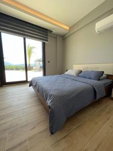 1 dormitorio con 1 cama grande y ventana grande en Villa Turunç 1, en Koycegiz