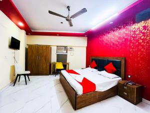 ein Schlafzimmer mit einem Bett und einer roten Wand in der Unterkunft Deluxe Room In Sarai Kaley Khan in Neu-Delhi
