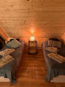 een kamer met 2 bedden en een lamp in een blokhut bij Sauna House Smyczyna in Smyczyna