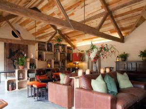a living room with leather furniture and wooden ceilings at The Grain Store- Dex in Marshwood