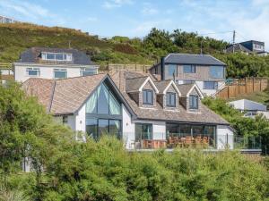 a house on top of a hill with trees at Blue Seas in Mawgan Porth