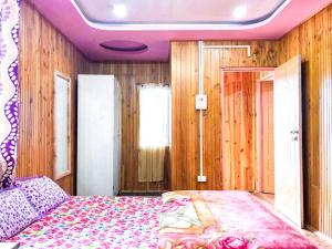 a bedroom with a bed with a purple ceiling at BODHI VILLA in Sombāri
