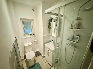 a white bathroom with a shower and a toilet at Downtown Chic Private Bedrooms in King's Cross 4 in London