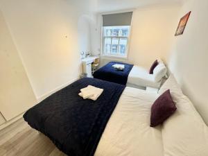 倫敦的住宿－Downtown Chic Private Bedrooms in King's Cross 4，酒店客房设有两张床和窗户。