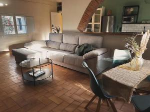 a living room with a couch and a table at Cal Robusto, Apartament in Masía with horses in Siurana