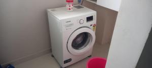 a washing machine in a corner of a room at OSKO GRAND REVIERA, 10TH FLOOR, VENPALAVATTOM, NEAR KIMS HOSPITAL, TRIVANDRUM, KERALA in Trivandrum