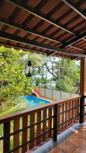 - un balcon avec vue sur la piscine dans l'établissement Lakefront Beach Homes, à Cherai Beach