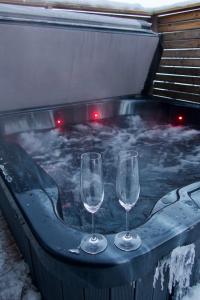 two wine glasses sitting in a hot tub with snow at Polaris Igloo Levi in Levi