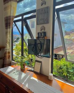 Pokój z biurkiem i oknem z widokiem na okolicę. w obiekcie ORIANA Đà Lạt w mieście Da Lat