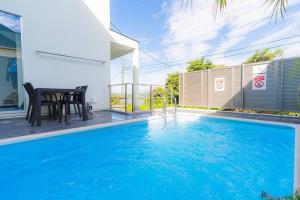 a pool with a table and chairs next to a house at unito Villa FUTTSU Takeoka in Futtsu