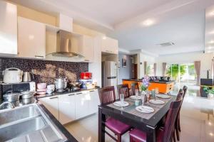 a kitchen with a table and chairs in a kitchen at Unique Pool Villa Resort in Ban Map Fakthong