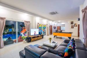 a living room with a couch and a pool table at Unique Pool Villa Resort in Ban Map Fakthong